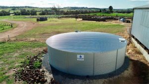 یک مخزن آب فلزی با ابعاد بزرگ که در یک مزرعه کشاورزی نصب شده